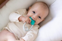 Chrastítko špendlík plast 12cm tyrkysovošedé 12x19cm v sáčku 0+